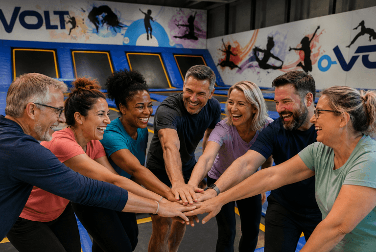 Équipe de travail qui fait un mouvement de ralliement devant des trampolines
